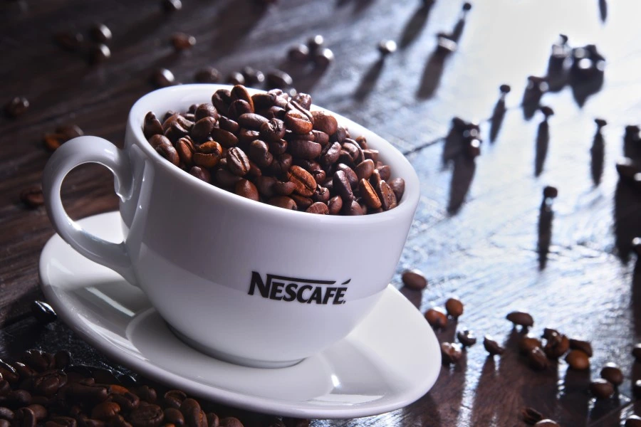 Coffee beans in a Nescafe cup.